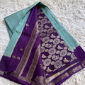 Purple saree with floral patterns on a white textured surface