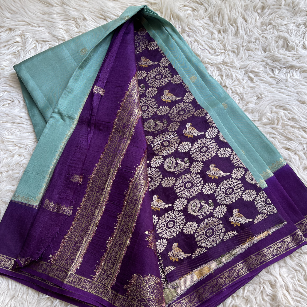 Purple saree with floral patterns on a white textured surface