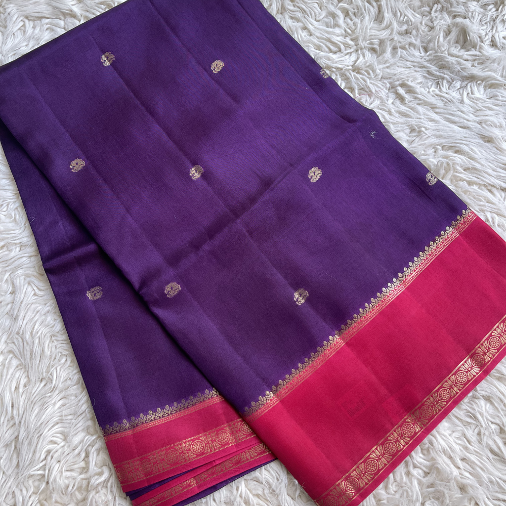 Viscous Dola silk with Purple and pink saree with gold bentex border on a white textured background