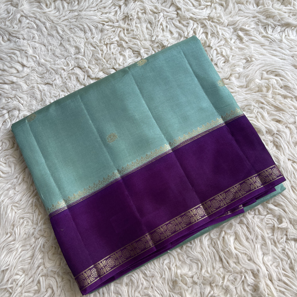 Viscous Dola silk  With Teal and purple saree with a textured white background
